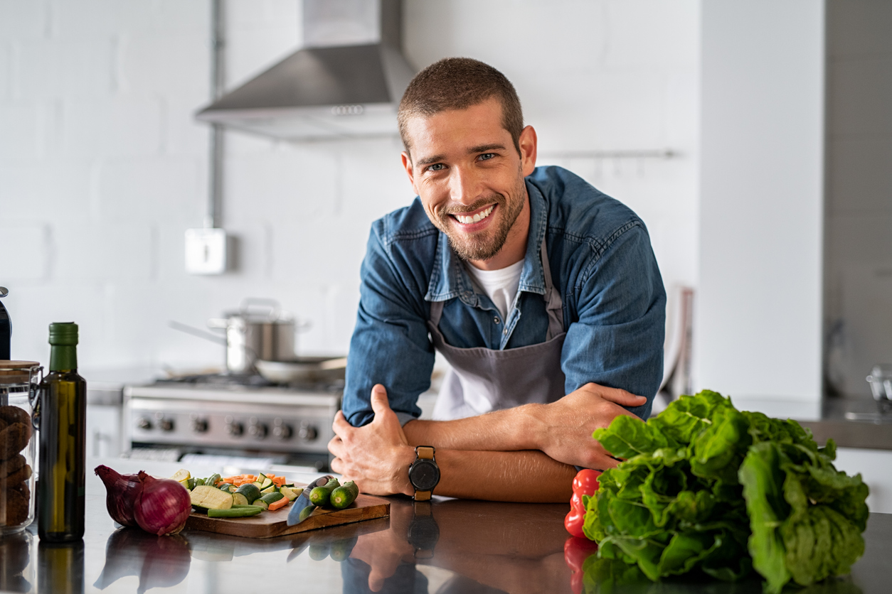 Happy man ready to cook in kitchen